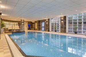 a large swimming pool in a hotel lobby with a large pool at DoubleTree by Hilton Stoke-on-Trent, United Kingdom in Stoke on Trent