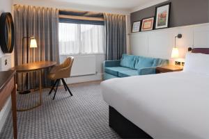 a hotel room with a bed and a desk and a couch at DoubleTree by Hilton Stoke-on-Trent, United Kingdom in Stoke on Trent