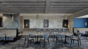 a restaurant with tables and chairs and a bar at DoubleTree by Hilton Raleigh Midtown, NC in Raleigh
