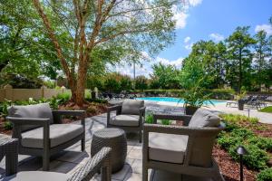 a patio with chairs and a swimming pool at DoubleTree by Hilton Raleigh Midtown, NC in Raleigh