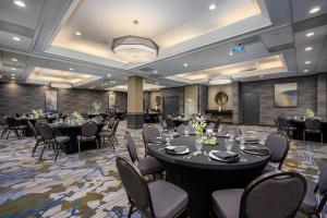 a banquet hall with black tables and chairs at DoubleTree by Hilton Raleigh Midtown, NC in Raleigh +22 photos