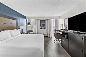 a hotel room with a large bed and a television at DoubleTree by Hilton Raleigh Midtown, NC in Raleigh