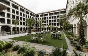 a courtyard with tables and chairs in a building at Estancia del Norte San Antonio, A Tapestry Hotel by Hilton in San Antonio