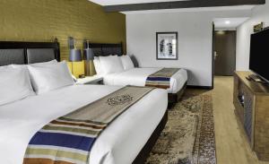 a hotel room with two beds and a flat screen tv at Estancia del Norte San Antonio, A Tapestry Hotel by Hilton in San Antonio +43 photos
