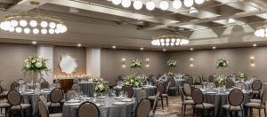 a banquet hall with tables and chairs and chandeliers at Estancia del Norte San Antonio, A Tapestry Hotel by Hilton in San Antonio