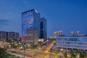 a city skyline with tall skyscrapers at night at Hilton Yancheng in Yancheng