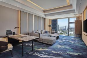 a living room with a couch and a table at Hilton Yancheng in Yancheng