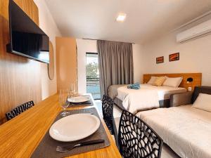 a hotel room with two beds and a table and a couch at Centro - flat completo para 4 pessoas in Brusque
