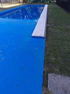 a swimming pool with blue water in a yard at Lenn Rem Eze in Ezeiza
