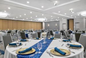 a conference room with tables and chairs with glasses and napkins at DoubleTree by Hilton Davenport in Davenport +55 photos