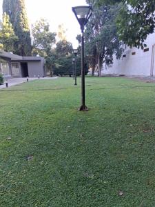 a light pole in the middle of a grass field at Lenn Rem Eze in Ezeiza
