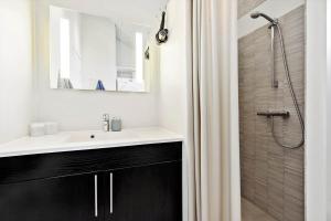 a bathroom with a sink and a shower with a mirror at 8529-Grenaa-Strandsletten-61 in Grenå +21 photos