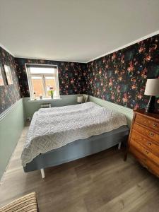 a bedroom with a bed and floral wallpaper at AE325-Marstal-Skovgyden-32 in Marstal