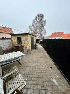 a patio with a wooden bench and a building at AE325-Marstal-Skovgyden-32 in Marstal