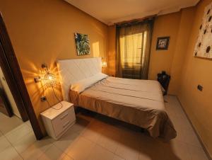 a small bedroom with a bed and a lamp at Paseo del mar in Melilla