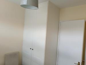 a white cabinet in a room with a mirror at Dublin Cosy Home in Dublin