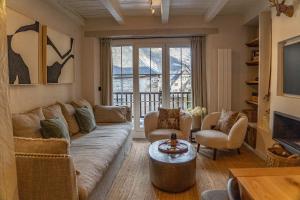 a living room with a couch and chairs and a tv at Arties Lodge in Arties