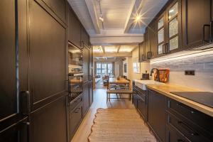 a kitchen with black cabinets and a table with a rug at Arties Lodge in Arties