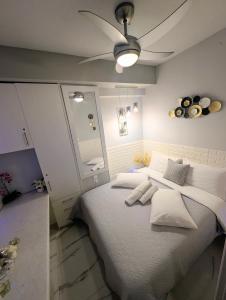 a bedroom with a large bed with a ceiling fan at EV Apartment with free parking place in Volos