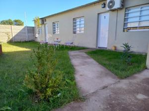 a house with two chairs in the yard at Departamentos TUNQUELEN in Colorado River