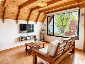 a living room with a bench and a table at Cabañas Chucao 2 in San Martín de los Andes
