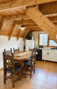 a kitchen with a wooden dining table and chairs at Cabañas Chucao 2 in San Martín de los Andes