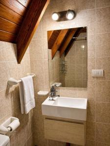 a bathroom with a sink and a mirror at Cabañas Chucao 2 in San Martín de los Andes +3 photos