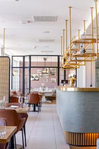 a restaurant with tables and chairs and a chandelier at Strandhotel Ostende Adults Only in Ahlbeck