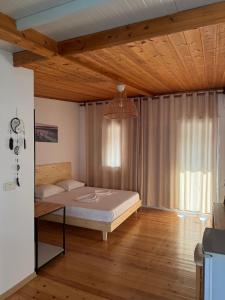 a bedroom with a bed and a wooden ceiling at Sea Breeze Rooms in Himare