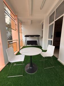 a table and chairs in a room with green grass at Central Dakar plateau apartment in Dakar
