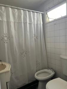 a bathroom with a toilet and a shower curtain at Depto calle 51 in La Plata