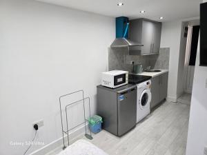 a kitchen with a washing machine and a microwave at Best room in Birmingham