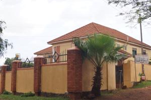 una casa con una palmera delante de ella en Durban Motel Najjanankumbi Kampala, en Kampala