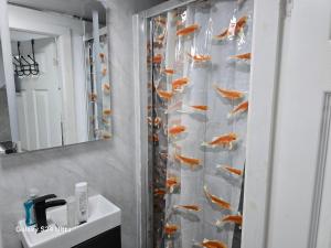 a bathroom with a shower curtain with goldfish at Best room in Birmingham