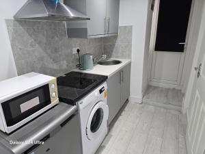 a kitchen with a sink and a washing machine at Best room in Birmingham +14 photos
