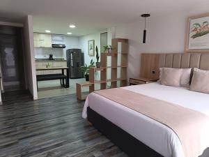 a bedroom with a large bed and a kitchen at Hotel 86 Suites in Bogotá