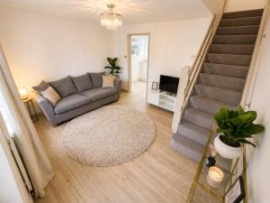 a living room with a couch and a staircase at Golden Sands Escape Weymouth Entire House in Wyke Regis