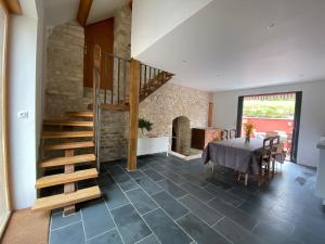 a dining room with a table and a spiral staircase at Le Verger de la Tannerie in Chesley