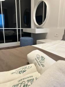 a bedroom with a bed with towels and a mirror at Tilia Lux apartmani in Čačak