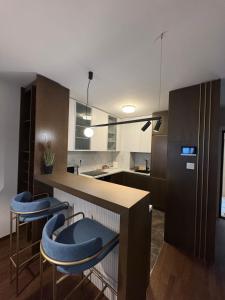 a kitchen with two blue stools at a counter at Tilia Lux apartmani in Čačak