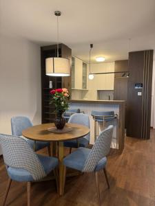 a dining room with a table and chairs and a kitchen at Tilia Lux apartmani in Čačak