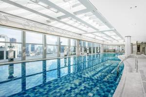 a large swimming pool with a view of the city at Conrad Shanghai in Shanghai