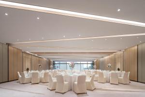 a banquet hall with white tables and white chairs at Conrad Shanghai in Shanghai +133 photos