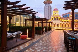 a patio with tables and chairs and a building at Conrad Shanghai in Shanghai