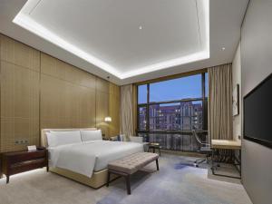 a bedroom with a white bed and a large window at Doubletree By Hilton Quzhou in Quzhou