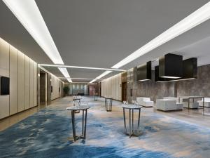 a lobby with tables and couches in a building at Doubletree By Hilton Quzhou in Quzhou +48 photos