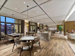a hotel lobby with tables and chairs and a bar at Doubletree By Hilton Quzhou in Quzhou