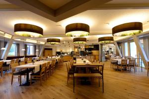 a dining room with tables and chairs and chandeliers at Hotel Schwarz Alm Zwettl in Zwettl Stadt