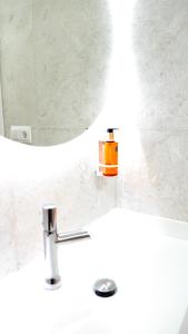 a bathroom sink with an orange soap container on it at Celta Home in Vigo +66 photos