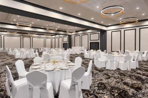 a ballroom with white tables and white chairs at Doubletree By Hilton Pointe Claire Montreal Airport West in Pointe-Claire +46 photos